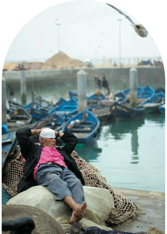 Moroccan man taking a nap in the heart of Essaouira port