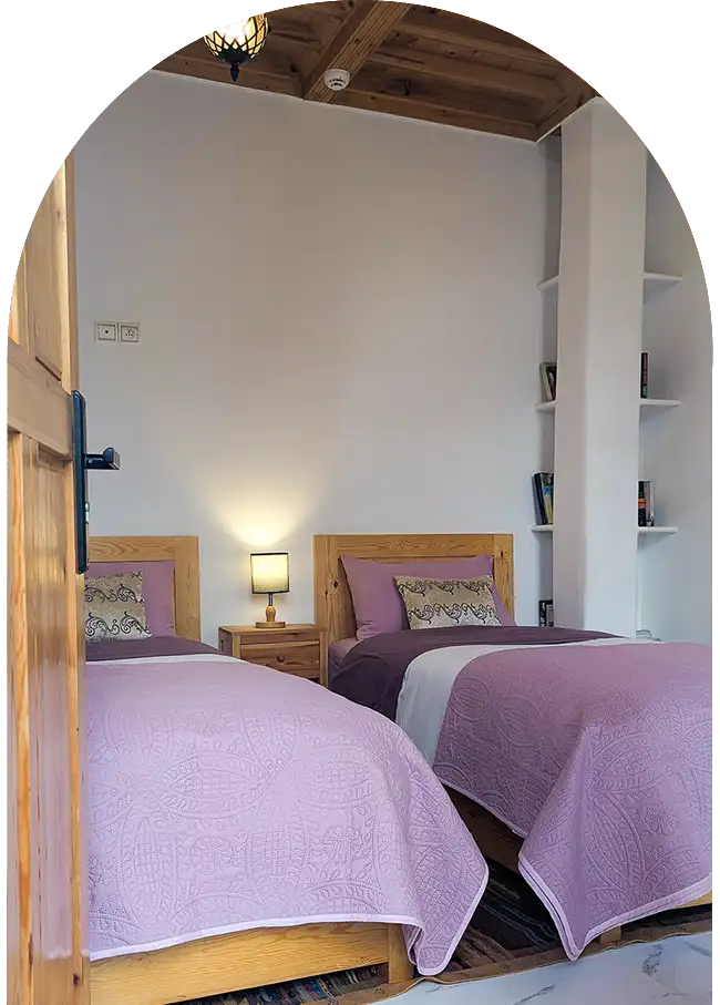 Petite chambre cosy au plafond en bois blond avec deux lits simples 