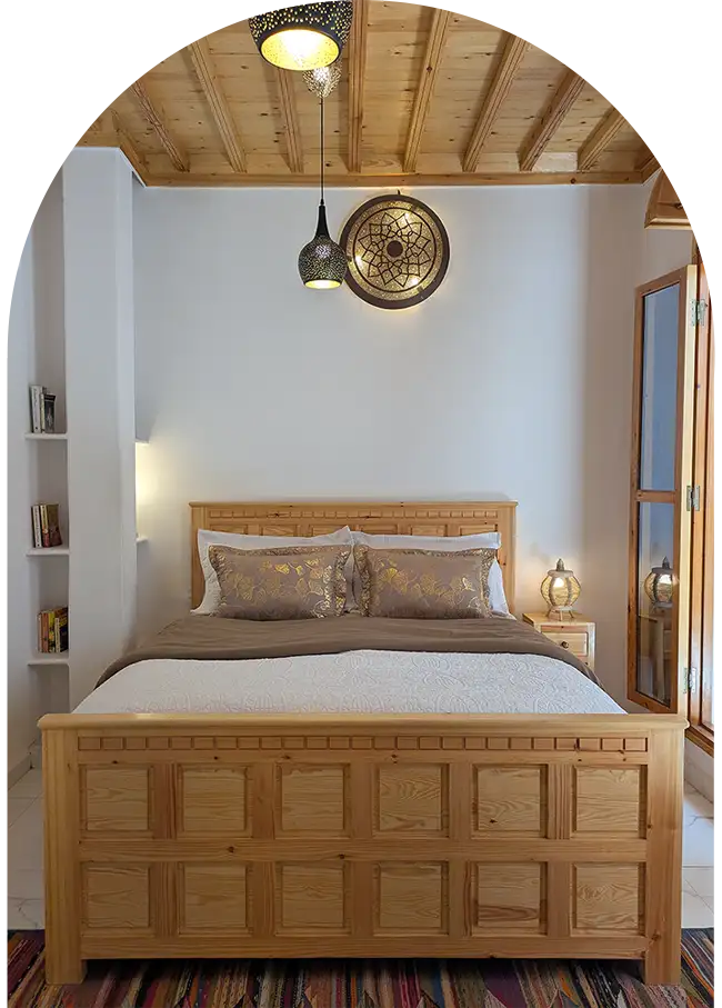 The family suite charms with its finely carved bed, blond wood ceiling, and large French doors opening onto the riad’s patio.