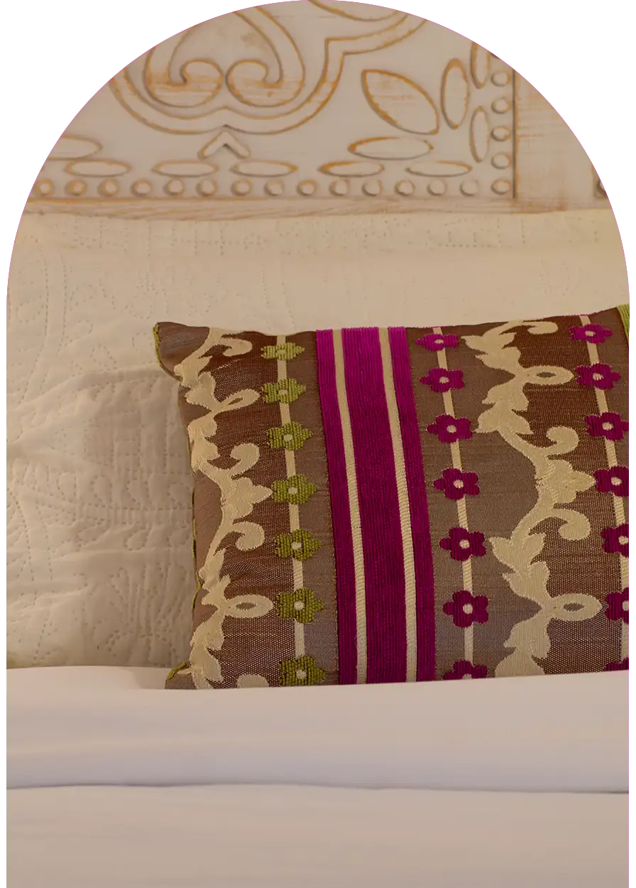 Colorful pillow and traditional carved wooden headboard, Moroccan decoration detail