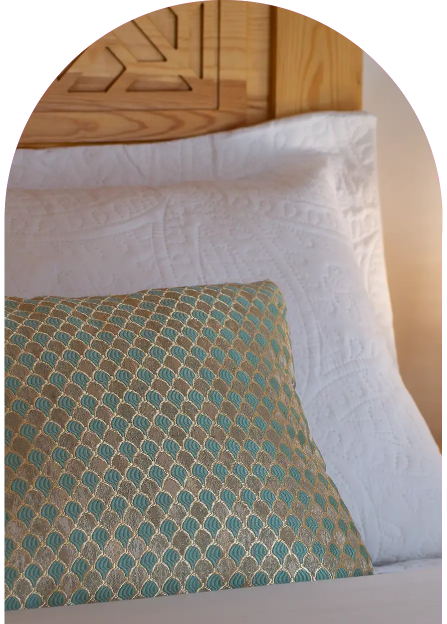 Colorful pillow and traditional carved wooden headboard, Moroccan decoration detail