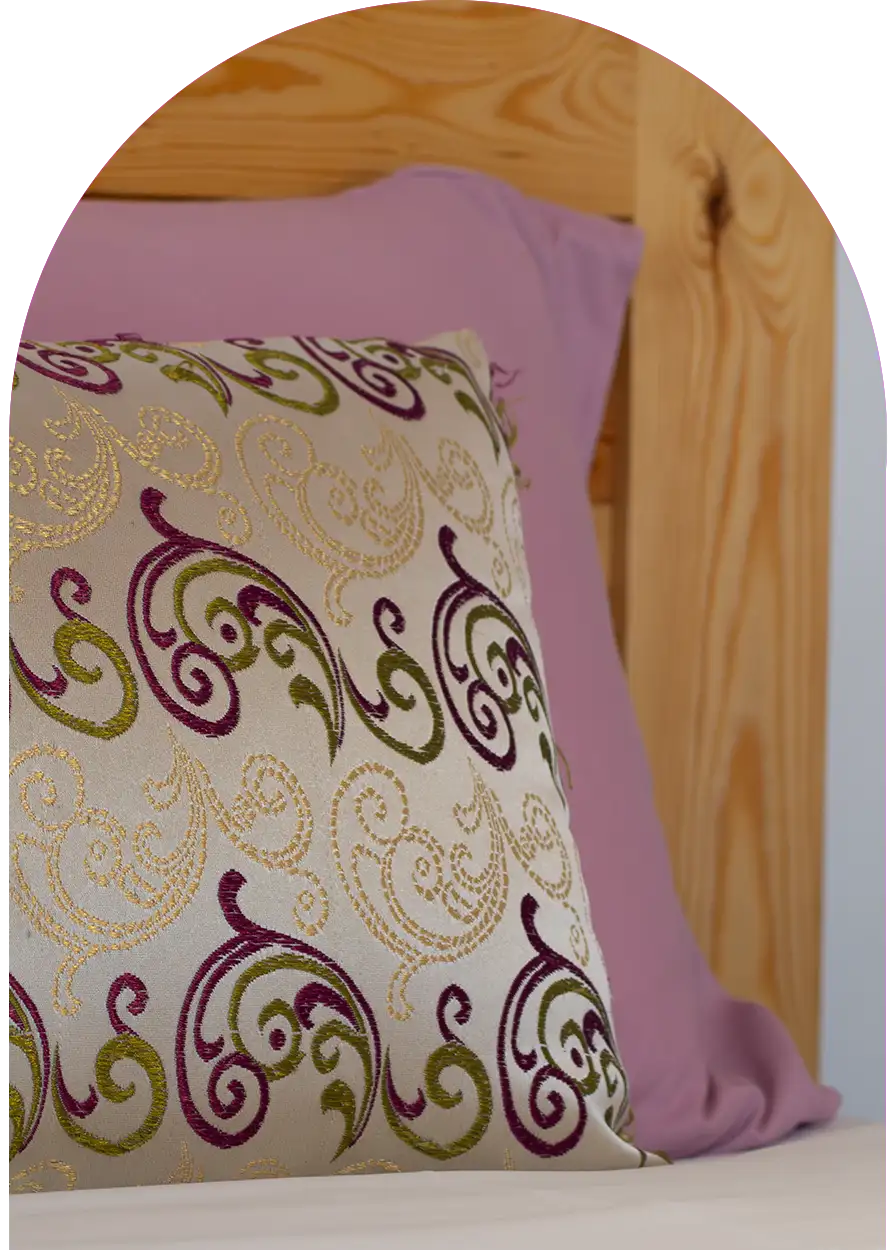 Colorful pillow and traditional carved wooden headboard, Moroccan decoration detail